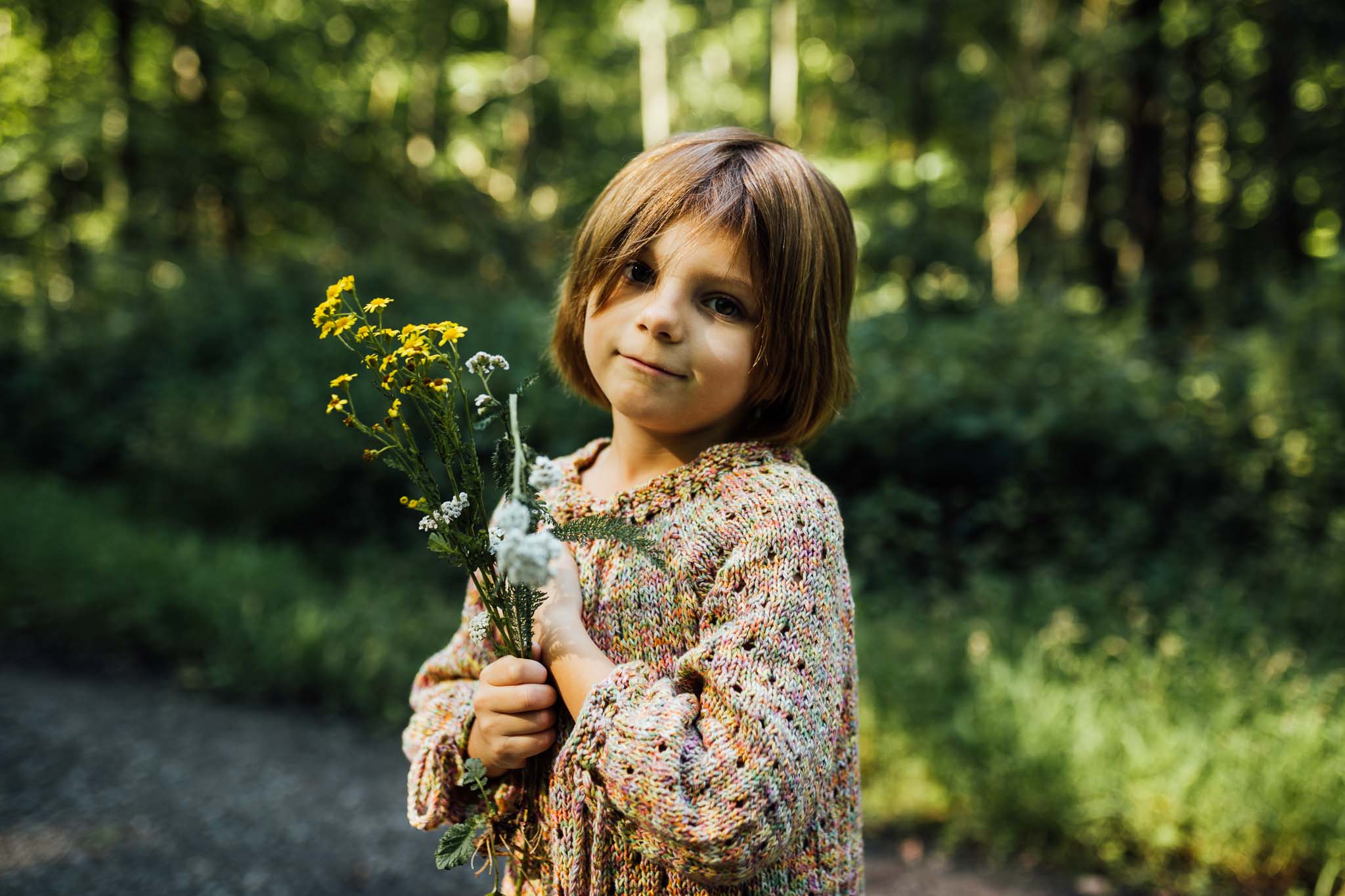 Mädchen mit Blumen in der Hand im Wald