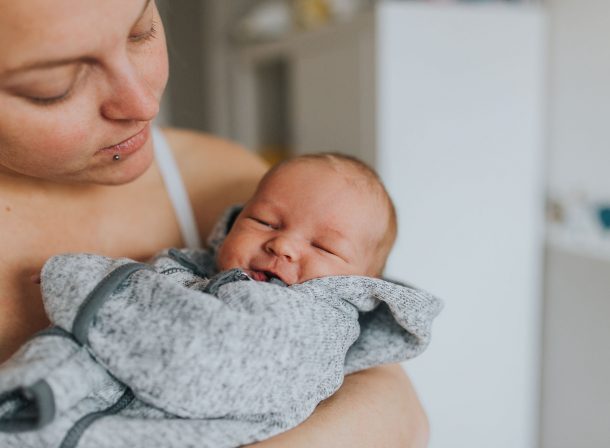 Newbornbaby auf dem Arm seiner Mutter